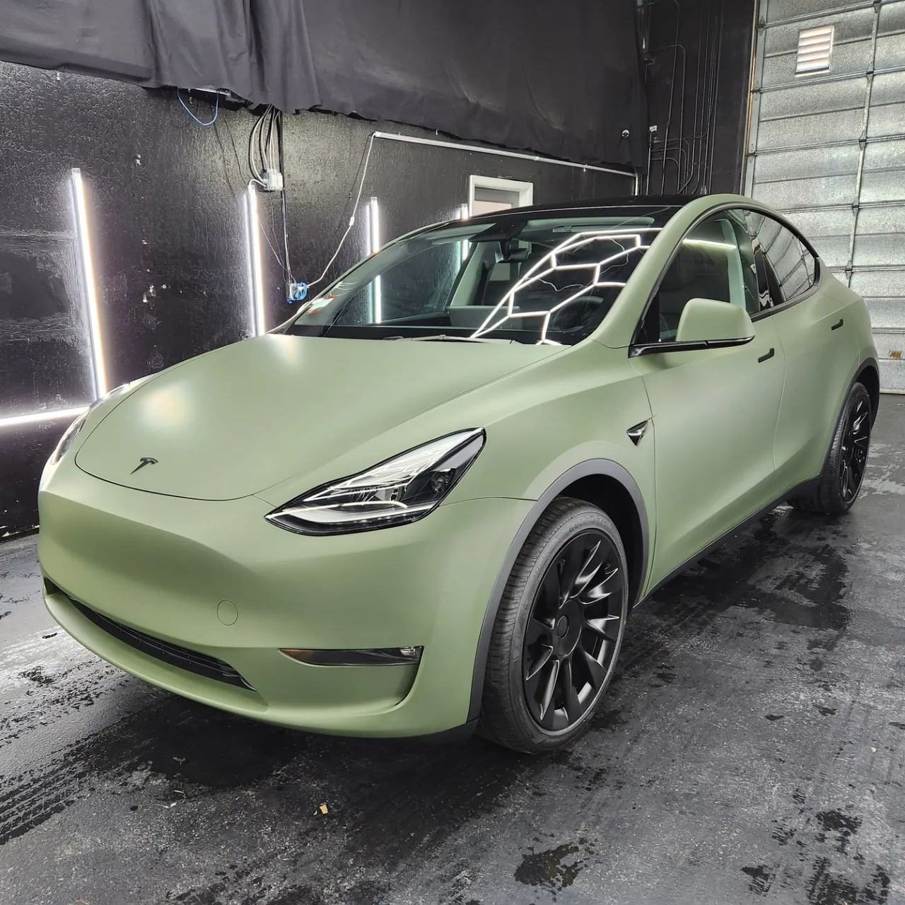 Matte green wrapped Tesla Model Y in the 68 Auto Film bay