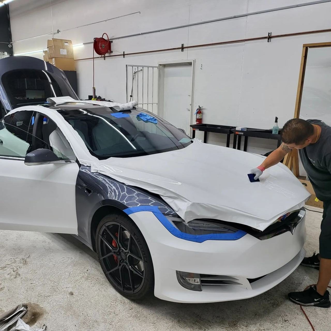 White Tesla Model S with film being installed on the front