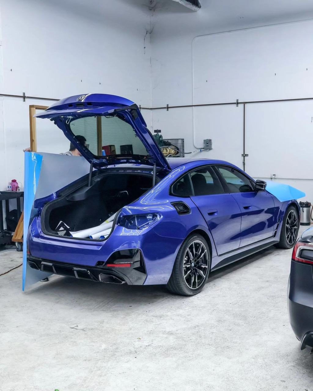 Blue BMW i4 with film being fitted in the 68 Auto Film shop