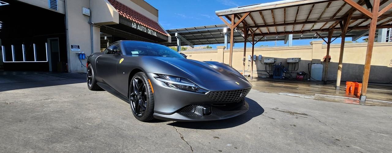 Matte grey Ferrari Roma in front of the 68 Auto Film bays