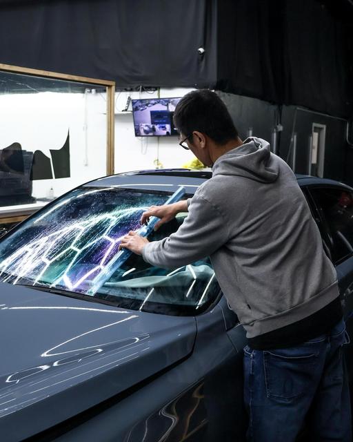 68 Auto Film installer applying film to a windshield