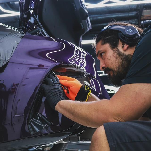 Technician working on a purple wrapped panel