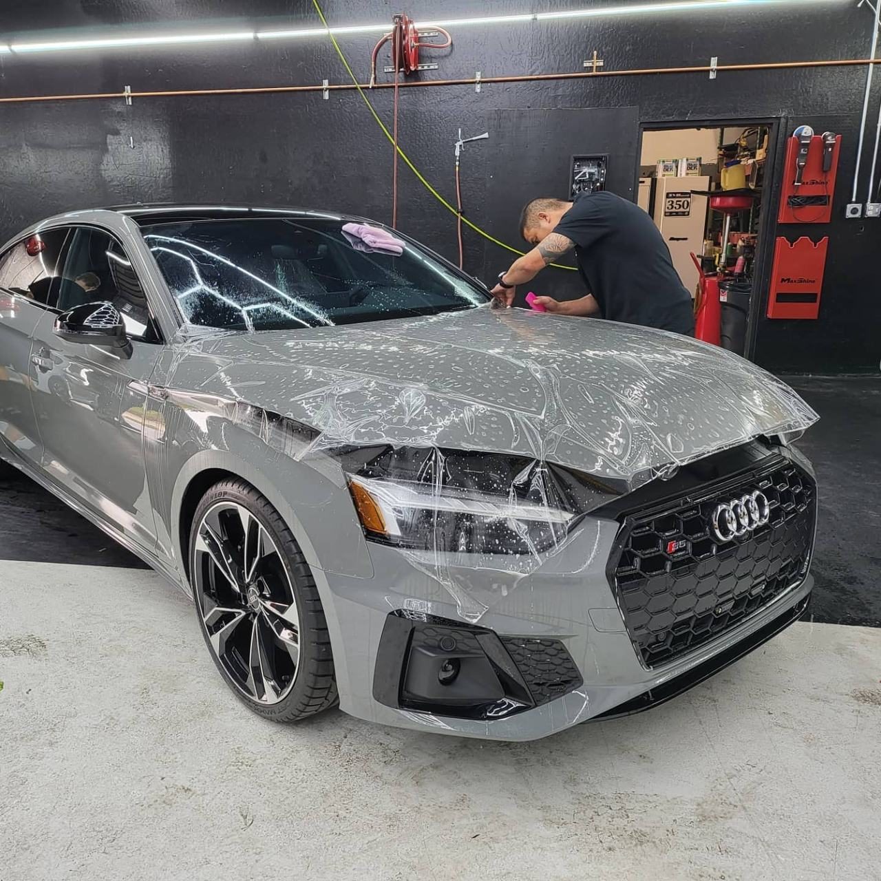 Grey Audi with clear film being installed on the front end